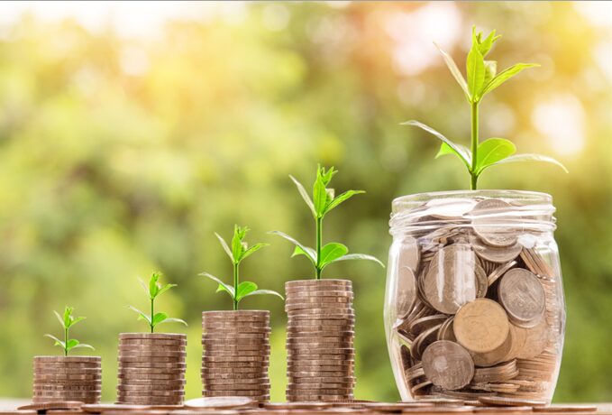 Seedlings coming out of sacks of and a jar of coins
