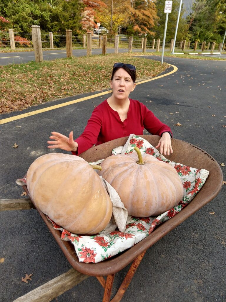 Debby Ward, Professional Organic Garden Coach, Teacher, Speaker and Designer and Writer, with two huge winter squash she grew.
